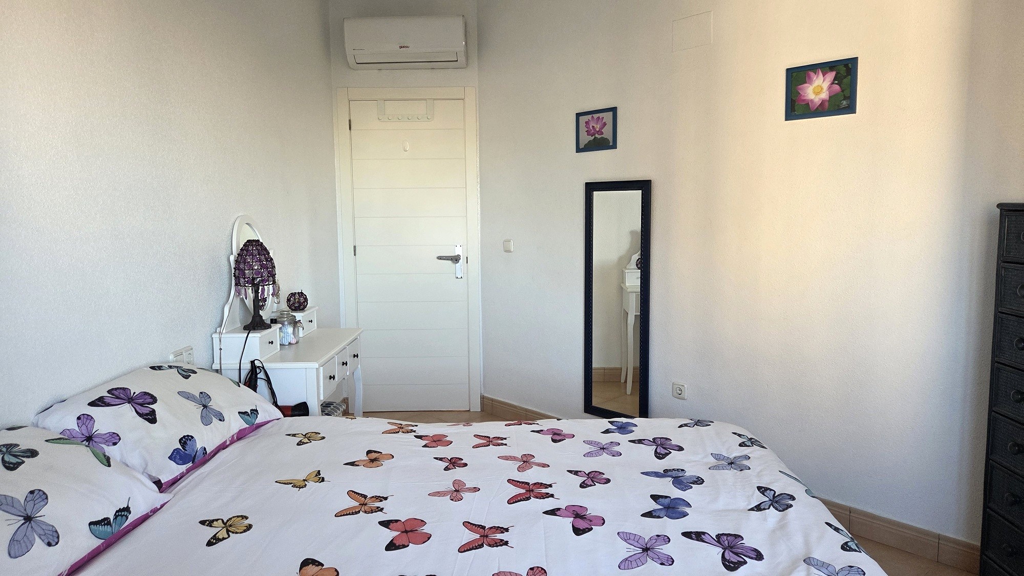 Dormitorio con cama vestida y tocador blanco