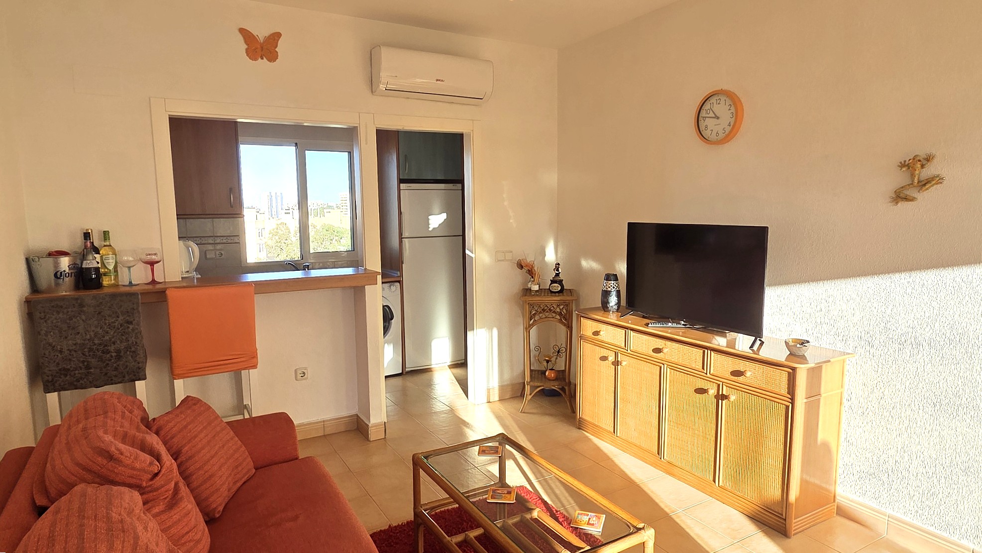 Salón con televisión, mueble de madera y luz natural